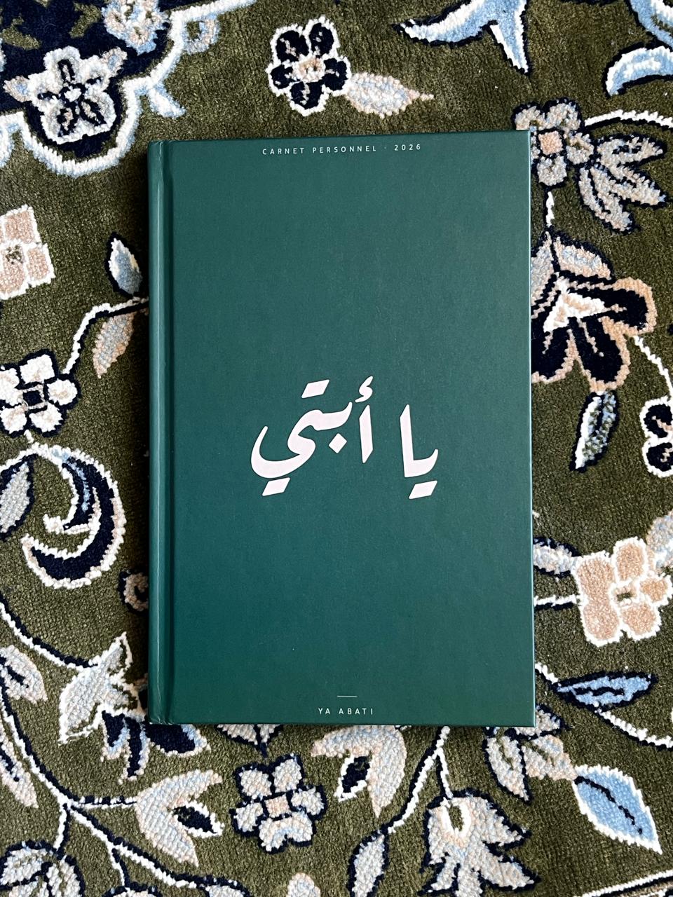 Carnet Ya Abati en édition limitée, posé sur un tapis ancien